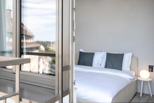 a bedroom with a bed next to a window at VISIONAPARTMENTS St Gallen - contactless check-in in St. Gallen