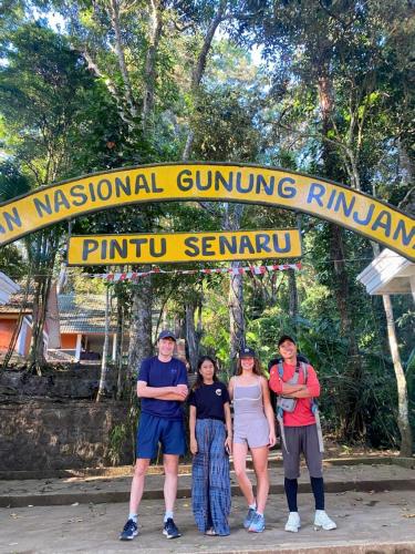 a group of people standing in front of a sign at Poetri Bungalow & Restaurant in Senaru