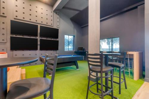 a gaming room with a ping pong table and chairs at SPOT X Hotel Tampa - Wesley Chapel by The Red Collection in Wesley Chapel