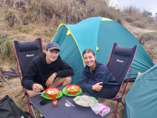 a man and woman sitting at a table in front of a tent at Poetri Bungalow & Restaurant in Senaru