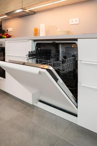 a dishwasher with its door open in a kitchen at KOVÁCS Hosťovský dom Vendégház Guesthouse in Veľké Blahovo
