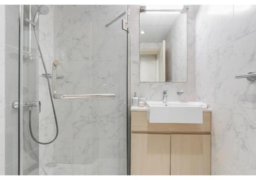 a bathroom with a shower and a sink and a shower at Bright and Modern 1BR Midtown Near Expo Site by Vibel in Dubai