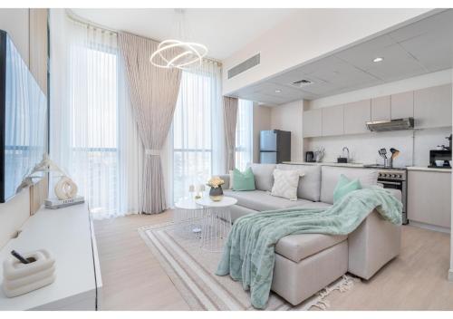 a living room with a couch and a kitchen at Bright and Modern 1BR Midtown Near Expo Site by Vibel in Dubai