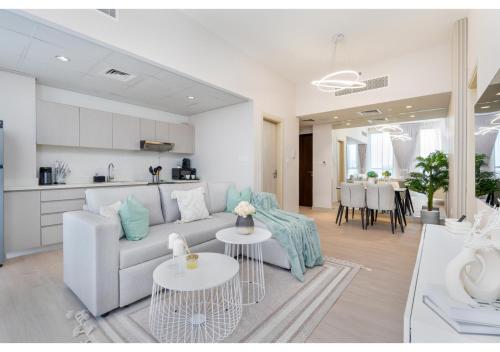 a living room with a couch and a table at Bright and Modern 1BR Midtown Near Expo Site by Vibel in Dubai