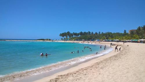a group of people in the water at a beach at Dre Broeders Apartments Juan Dolio in Juan Dolio