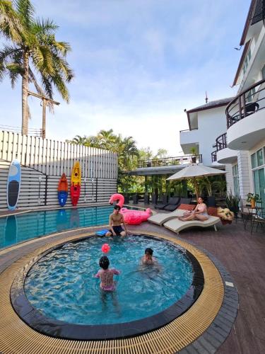 a group of people in a pool at a resort at A-Te Chumphon Hotel - SHA Plus in Chumphon