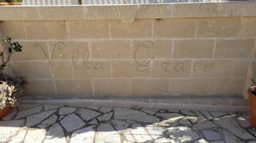 a brick wall with the words hello peace written on it at Villa Grace in Selva di Fasano
