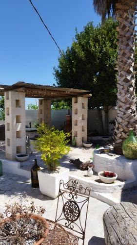 a patio with a table and a bench and trees at Villa Grace in Selva di Fasano