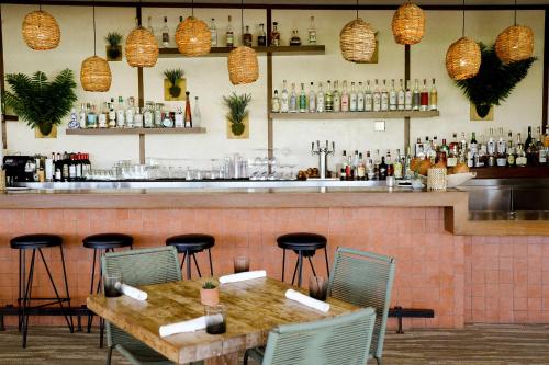 a restaurant with a bar with a table and chairs at Hotel June West LA, a Member of Design Hotels in Los Angeles