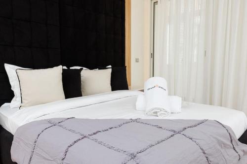 a bedroom with a large bed with white sheets at Elegant 2BR in Hay Riad - New Furnishings & Design in Beni Brour