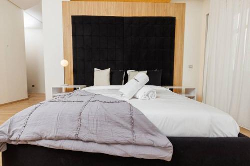 a bedroom with a large bed with white sheets and pillows at Elegant 2BR in Hay Riad - New Furnishings & Design in Beni Brour