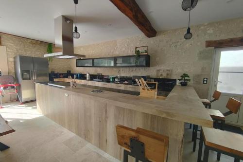 une grande cuisine avec un grand comptoir en bois dans l'établissement La grange aux noix 20min du zoo près du plan d'eau, à Monthou-sur-Cher