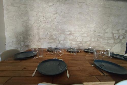 - une table en bois avec des verres et des assiettes dans l'établissement Les capucines proche Beauval & châteaux, à Saint-Aignan