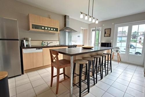 une cuisine avec un îlot et des tabourets de bar dans l'établissement Gîte du petit ruisseau 6,5km du zoo, à Mareuil-sur-Cher