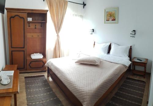 a bedroom with a bed and a large window at Casa Irina in Durau