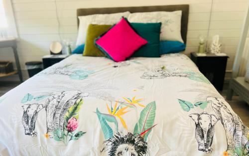 a bed with a white comforter with elephants on it at Lavender Lodge in Corfe Mullen