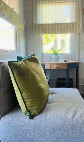 a yellow pillow sitting on top of a couch at Lavender Lodge in Corfe Mullen