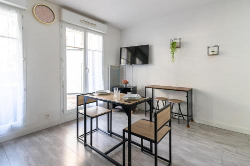 une salle à manger avec une table et des chaises dans l'établissement Le Bougainvillier - charmant studio avec balcon, à Bussy-Saint-Georges