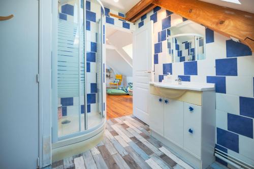 BaromesnilにあるLa Baronnerie Normande - Piscine et jacuzziの青と白のタイルの壁のバスルーム