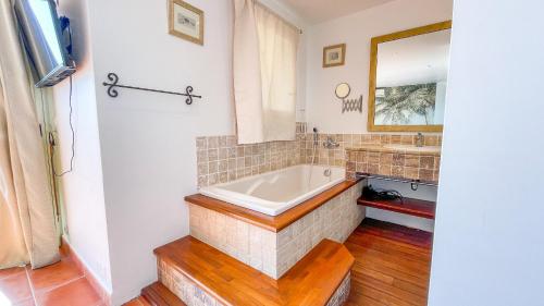 une salle de bain avec une baignoire et un miroir dans l'établissement Villa Stella, à Conca