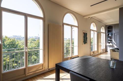 une salle à manger avec de grandes fenêtres et une table dans l'établissement Luxury 4 Bedroom Eiffel Tower View, à Paris