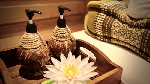 a group of three vases and a flower on a table at A-Te Chumphon Hotel - SHA Plus in Chumphon