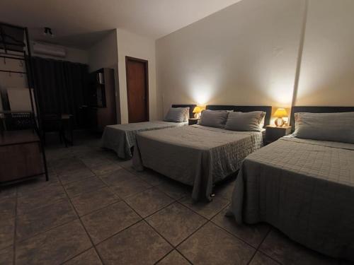 a hotel room with two beds in a room at Villa Bilac - Amplos Studios 2km da Vila Germânica in Blumenau