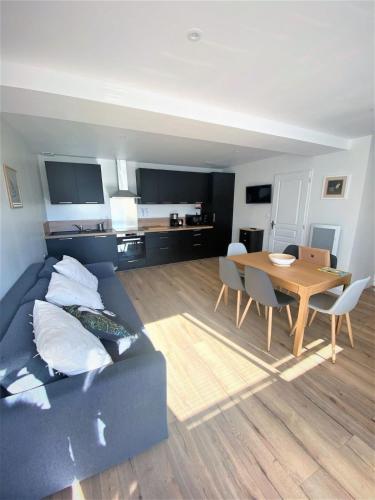 un salon avec un canapé bleu et une table dans l'établissement La Maison d'Elena 1,5km du Zoo,confortable et détente assurée, à Seigy