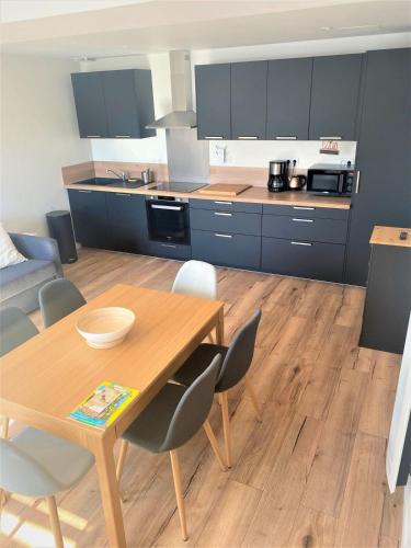 - une cuisine avec une table et des chaises en bois dans la chambre dans l'établissement La Maison d'Elena 1,5km du Zoo,confortable et détente assurée, à Seigy