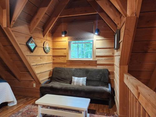 a living room with a couch in a log cabin at Keepers Quarters in Mount Nebo