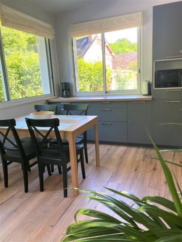 une cuisine avec une table et des chaises dans une pièce dans l'établissement Le Jardin d'Ana et La Maison d'Elena 15km du Zoo, à Seigy