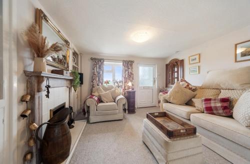 a living room with a couch and a fireplace at Cottage On The Common in Great Malvern