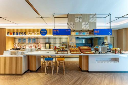 a fast food restaurant with a counter with stools at Holiday Inn Express Wuxi East Station by IHG in Wuxi