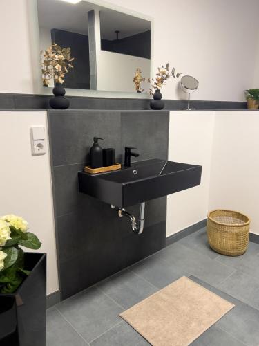 a bathroom with a black sink and a mirror at Stilvoll-Fewo mit Garten in Spremberg