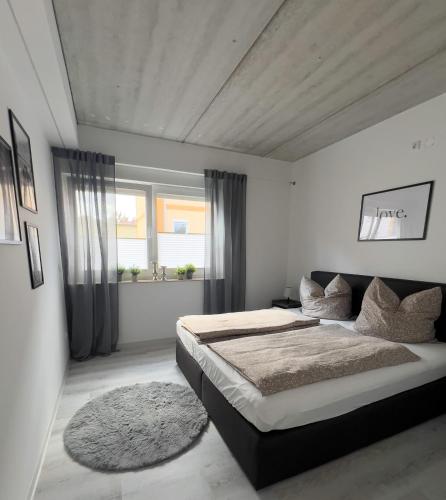 a bedroom with a large bed and a window at Stilvoll-Fewo mit Garten in Spremberg