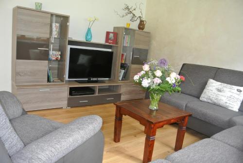 a living room with a vase of flowers on a table at Ferienhaus Baumberger in Oberammergau