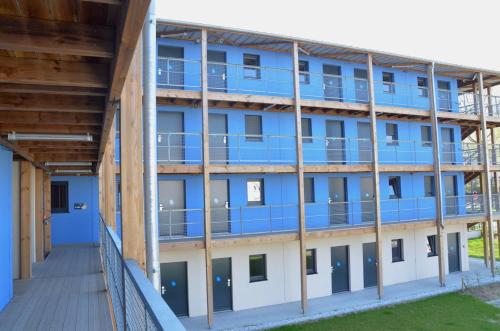 an external view of an apartment building with blue balconies at Eklo Hotels Le Havre in Le Havre