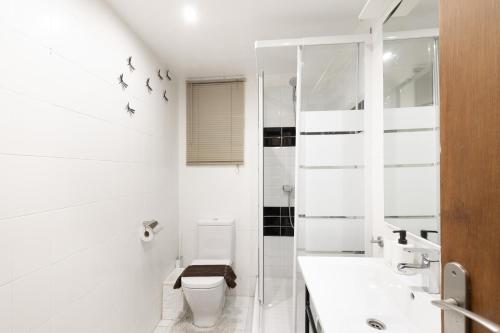 een witte badkamer met toilet en douche bij Bonito piso cerca de park guell in Barcelona