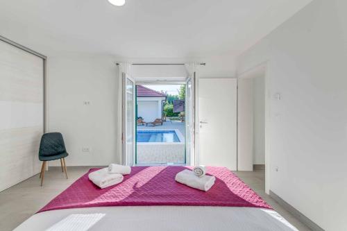 een slaapkamer met een bed met twee handdoeken erop bij Villa Great Escape in Šumet