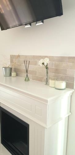 a white fireplace with flowers on top of it at Casa Rosamari - su Lago di Posta Fibreno, Appartamento con camino in Posta Fibreno