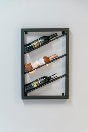 a glass shelf with three bottles of wine at Hotel Hola Medellín in Medellín