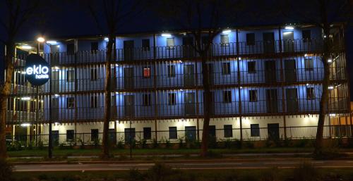 a large building with lights in front of it at night at Eklo Hotels Le Havre in Le Havre