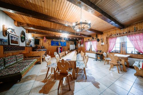 a large room with wooden ceilings and tables and chairs at Air ROOMS in Holiša