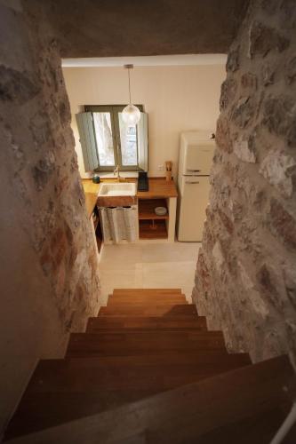 a stairway leading to a kitchen with a stone wall at Kallis Stone Houses in Areopolis