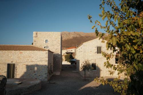 an alley between two buildings with a mountain in the background at Kallis Stone Houses in Areopolis