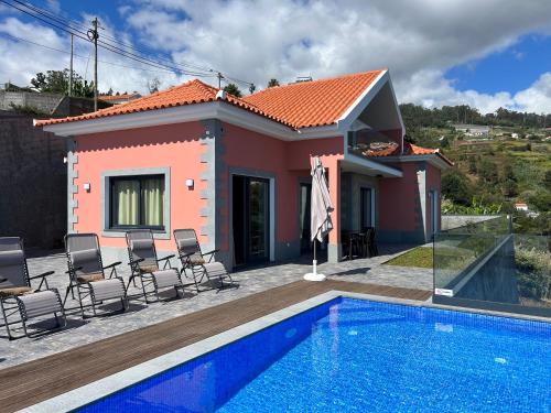 a villa with a swimming pool in front of a house at Villa Diogo in Ponta do Sol