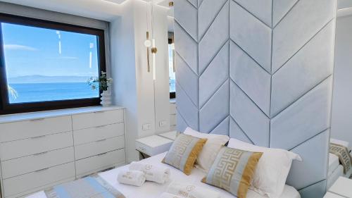 a bedroom with a large window and a bed with pillows at Agnanti villa Seafront with Pool in Paliouri