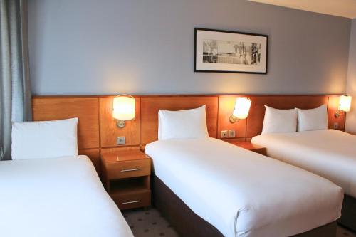 a hotel room with two beds and two lights at The Crown London, WorldHotels Distinctive in London