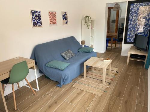 a living room with a blue couch and a table at Studio Solviou in Six-Fours-les-Plages