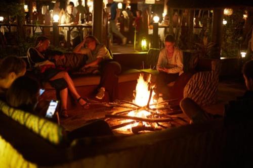 a group of people sitting around a fire pit at Camp Bastian Mikumi in Mikumi